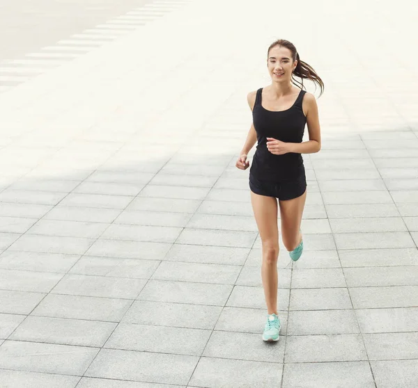 Mujer joven corriendo en el espacio de copia de la ciudad — Foto de Stock