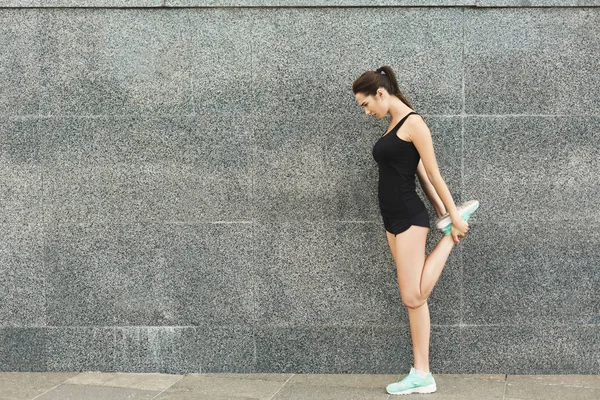 Genç bayan koşucu koşmadan önce ısınıyor. — Stok fotoğraf