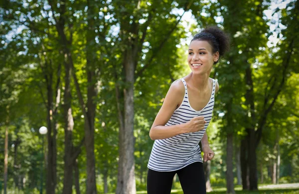 Mujer joven corriendo en el parque verde, espacio de copia — Foto de Stock