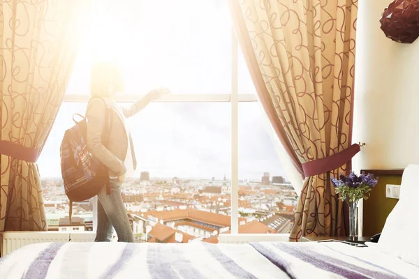 Женщина, стоящая у окна в гостиничном номере — стоковое фото