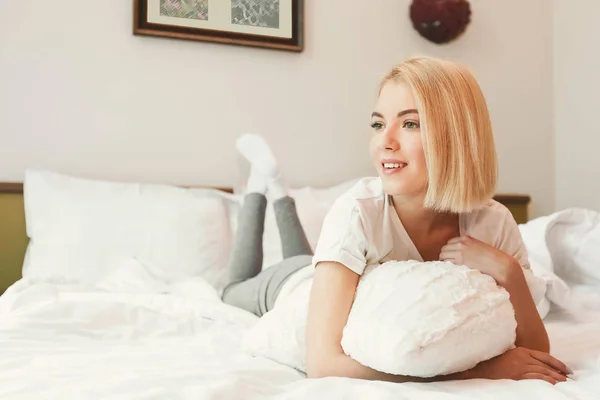 Jolie jeune femme au lit dans la chambre d'hôtel — Photo