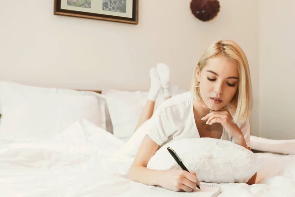 Jolie jeune femme couchée sur le lit dans la chambre d'hôtel — Photo