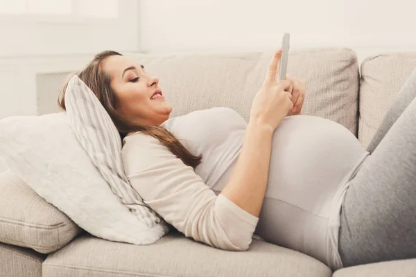 Happy pregnant woman using smartphone — Stock Photo, Image