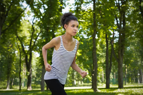 Mujer joven corriendo en el parque verde, espacio de copia — Foto de Stock