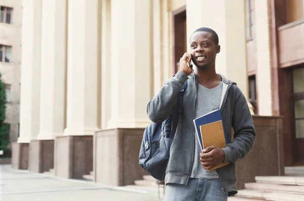 Feliz estudiante afroamericano hablando en un smartphone en el campus — Foto de Stock