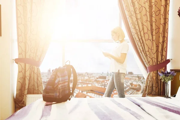 Vrouw stond in de buurt van het venster in hotelkamer — Stockfoto