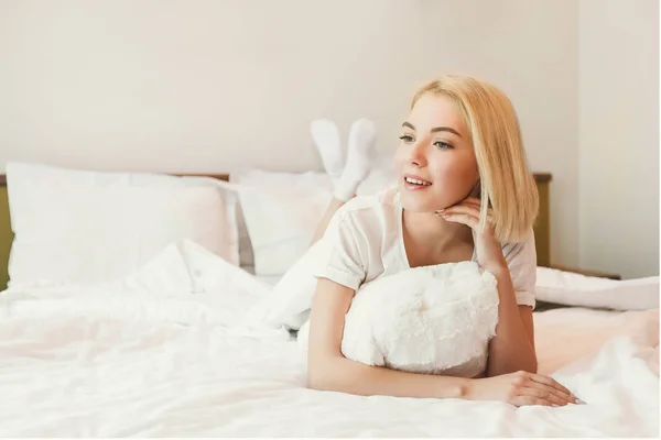 Jolie jeune femme au lit dans la chambre d'hôtel — Photo