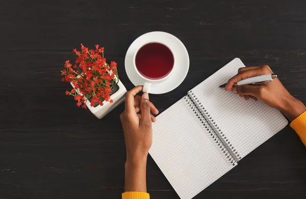 Black female hands writing in notebook, top view — Stock Photo, Image