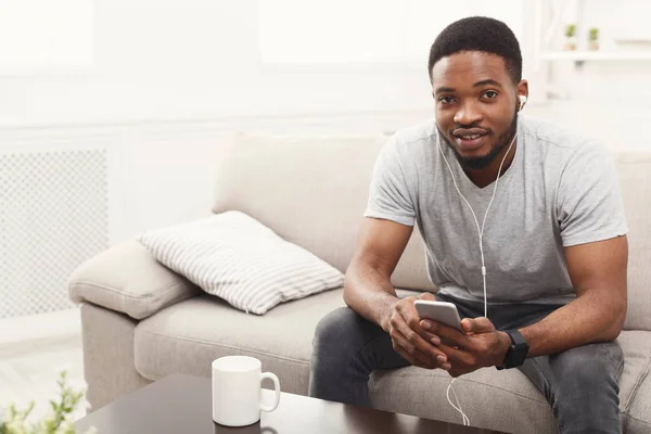 Afrikalı-Amerikalı genç adam cep telefonu kulaklık — Stok fotoğraf