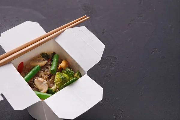 Asian food in delivery box on gray background — Stock Photo, Image