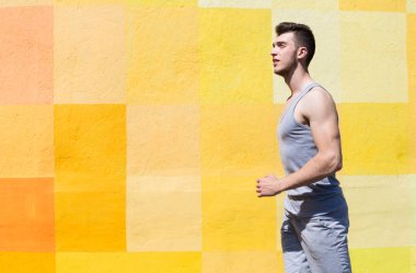 Parlak duvara koşan adam yan görünüm