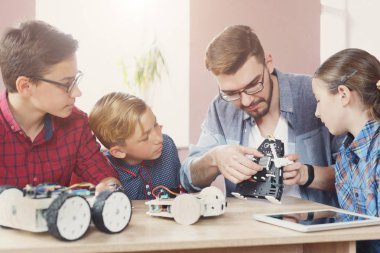 Eğitim kaynaklanıyor. Çocuklar robotlar öğretmen ile oluşturma