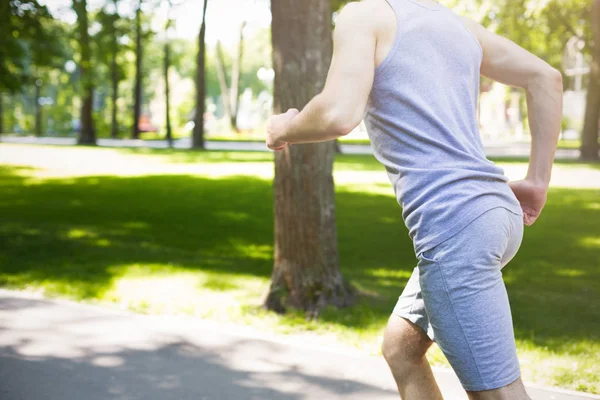 Junger Mann läuft im grünen Park, kopiert Raum — Stockfoto