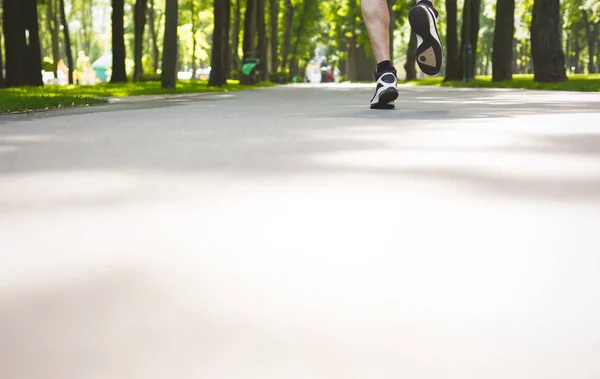 Молодой человек бегает по зеленому парку, копирует пространство — стоковое фото