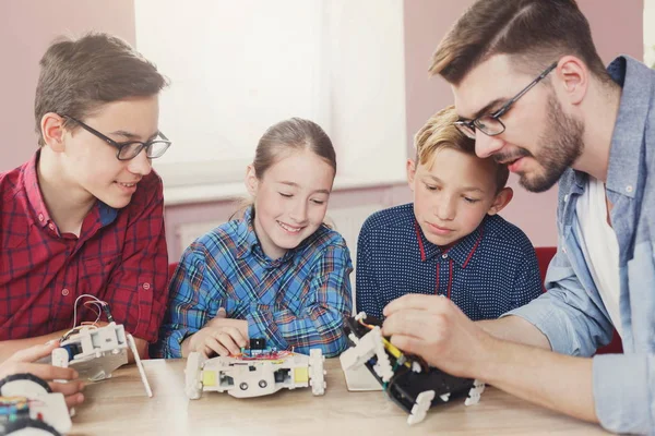 Stem education. Kids creating robots with teacher — Stock Photo, Image