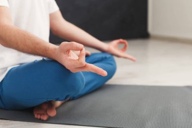 Genç adam spor salonunda meditasyon