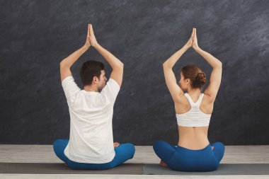 Genç çift padmasana içinde oturan yoga uygulamak