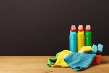 Colorful group of cleaning supplies on dark background clipart