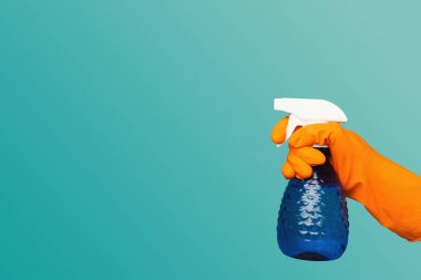 A hand in glove holding spray of cleaning fluid clipart