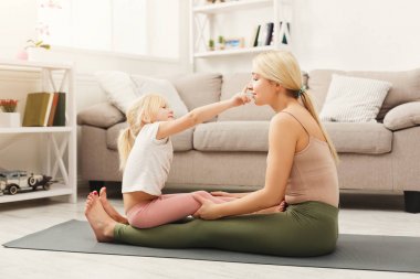 Anne ve kızı yoga egzersizleri evde yapıyor