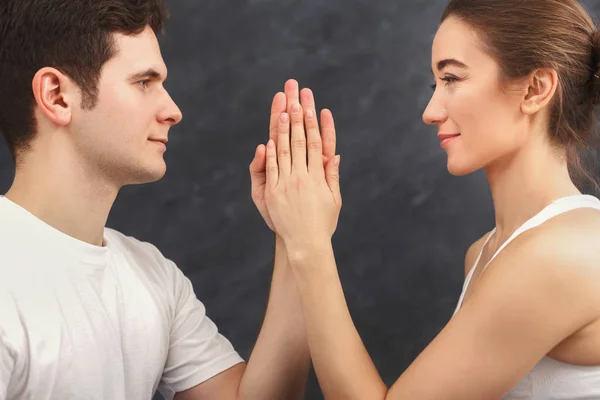 Casal jovem praticando ioga juntos no ginásio — Fotografia de Stock