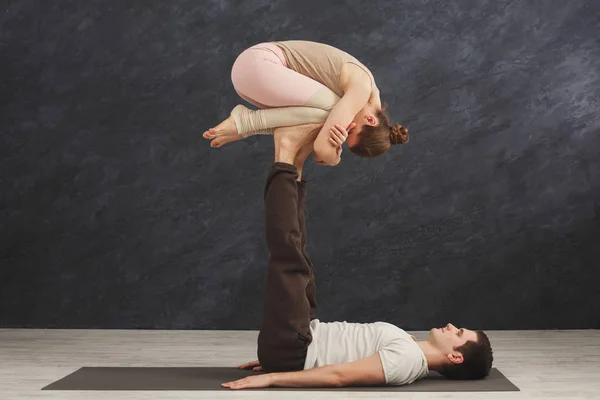 若いカップルが一緒にマットで acroyoga の練習 — ストック写真