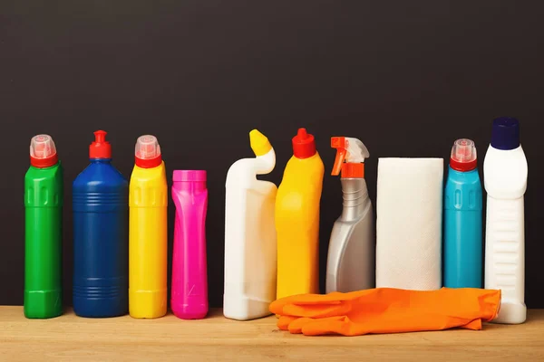 Grupo de produtos de limpeza coloridos em fundo escuro — Fotografia de Stock