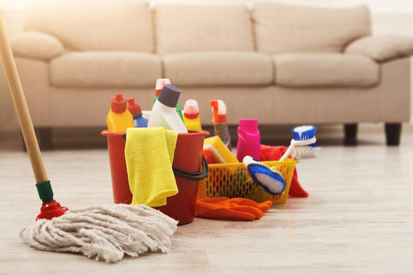 Bucket with sponges, chemicals bottles and mopping stick.