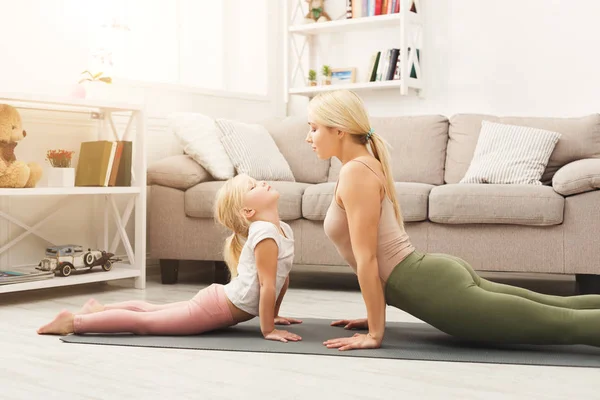Mother and daughter doing yoga exercises at home — Stock Photo, Image