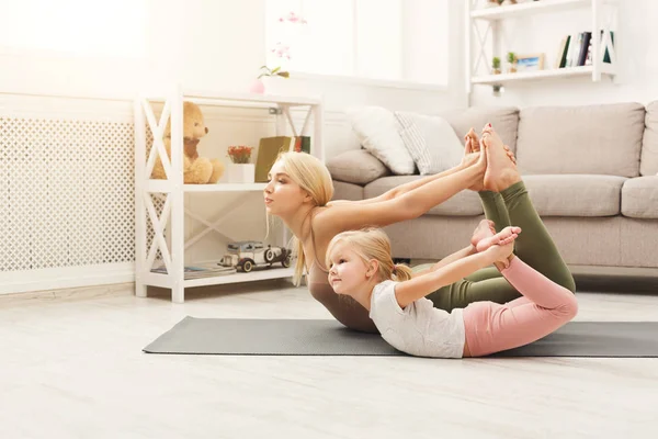 Mother and daughter doing yoga exercises at home — Stock Photo, Image