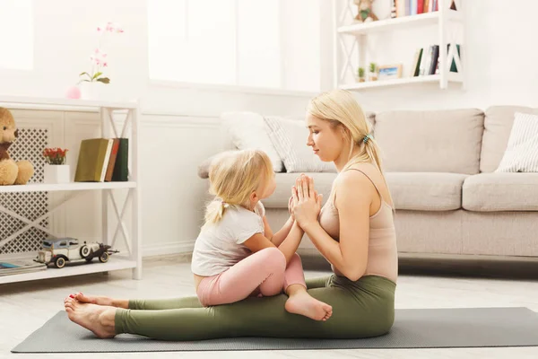 Happy mother and daughter hugging while home yoga class — Stock Photo, Image