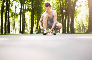 Adam çalıştırmadan önce ayakkabı bağcığı bağlama