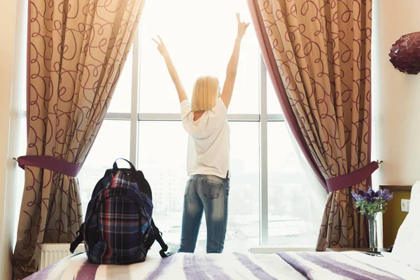 Vrouw stond in de buurt van het venster in hotelkamer — Stockfoto