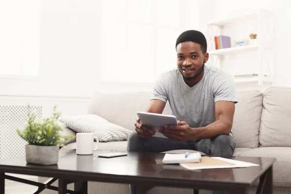 Young man at home messaging online on tablet — Stock Photo, Image