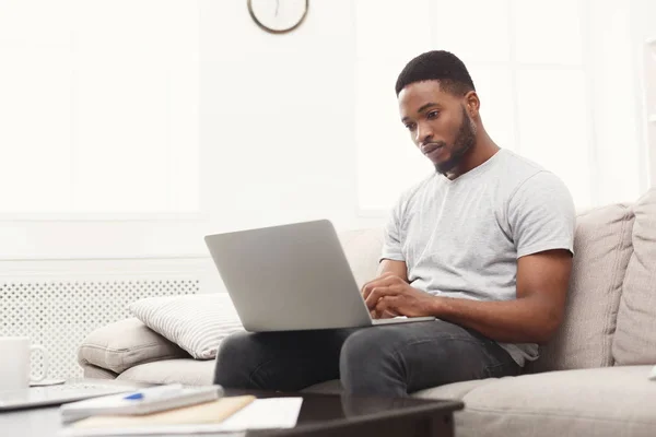 Young man at home messaging online on laptop — Stock Photo, Image