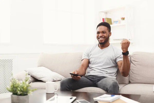 Homem feliz assistindo tv usando controle remoto na sala de estar — Fotografia de Stock