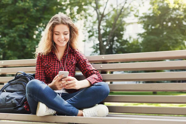 Szép asszony ült, és hallgatta a zenét a smartphone a szabadban — Stock Fotó