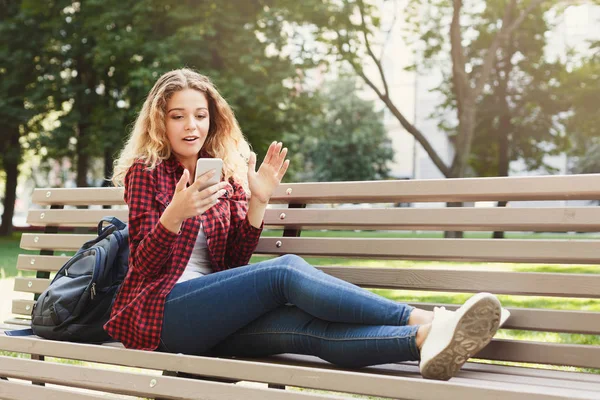 Döbbenve, nő a smartphone szabadban Hírek olvasása — Stock Fotó