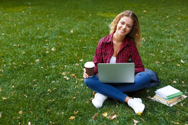 Mujer joven sonriente con portátil al aire libre — Foto de Stock