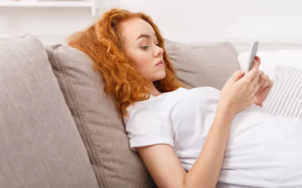 Nadenkend jong meisje texting op smartphone — Stockfoto