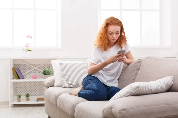 Pensive young girl texting on smartphone — Stock Photo, Image