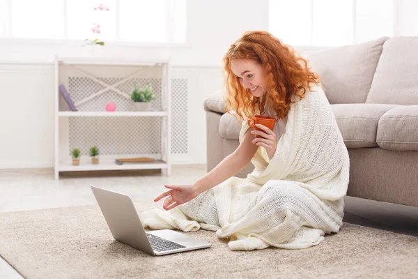 家での自由な時間を楽しんでいます。ノート パソコンと一杯のコーヒーで陽気な女の子 — ストック写真