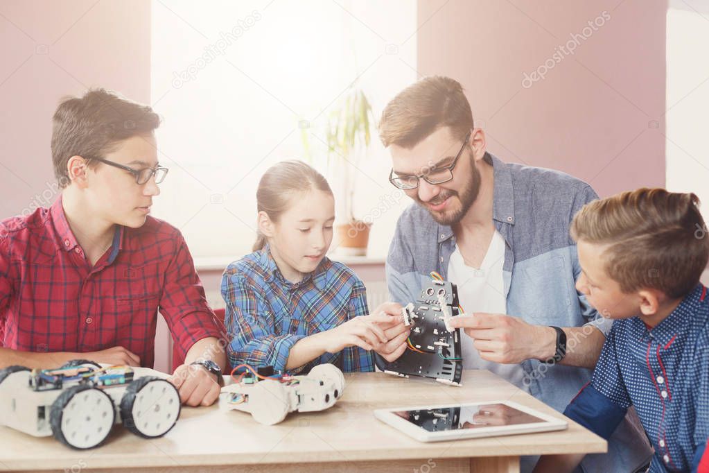 Stem education. Kids creating robots with teacher