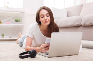 Dizüstü bilgisayar ve cep telefonu kullanan öğrenci kız