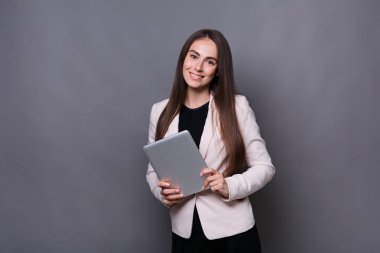 Gri zemin üzerine tablet ile mutlu kadın