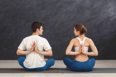 Yoga sınıfındaki genç çift geri germe