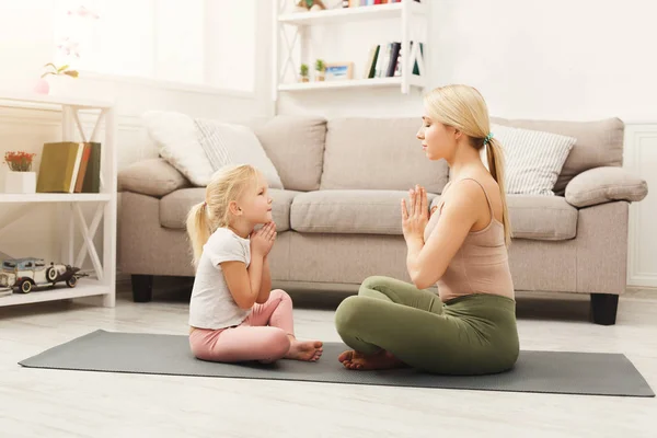 Moeder en dochter doen yoga oefeningen thuis — Stockfoto