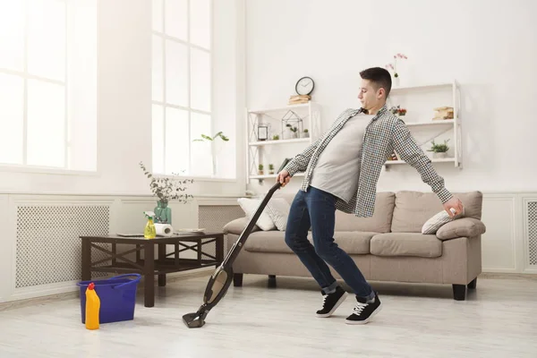 Joven limpiando casa, jugando con aspiradora — Foto de Stock