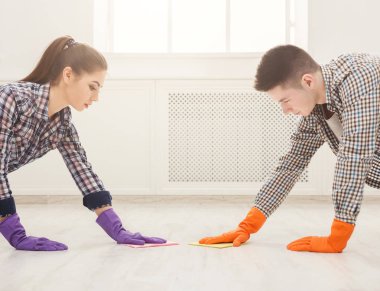 Young couple washing floor together