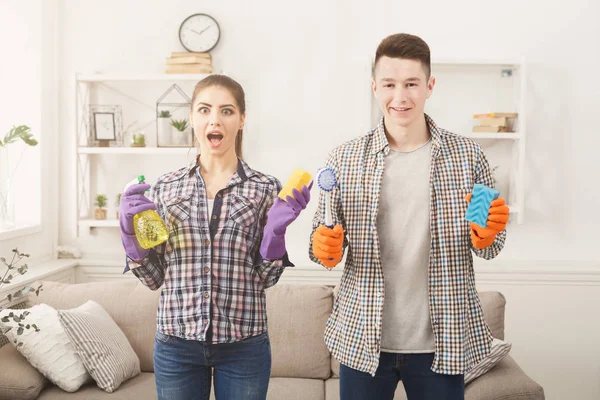 Jovem casal segurando equipamentos de limpeza em casa fundo interior — Fotografia de Stock